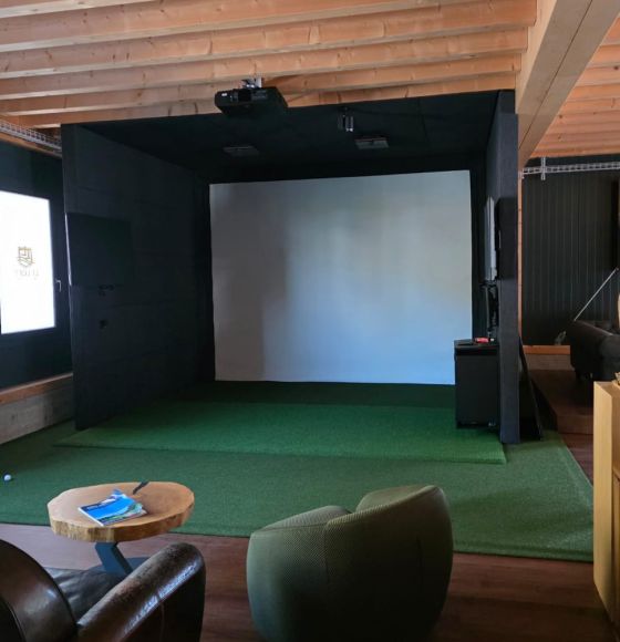 Golfeur au moment du swing devant le simulateur du Loft Network
